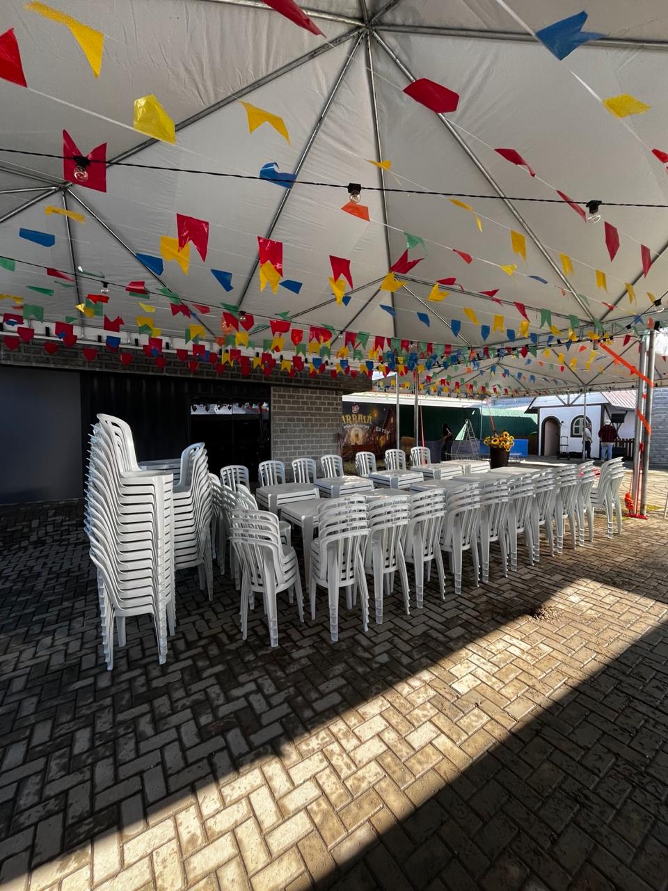 Mesas e cadeiras em evento com cobertura